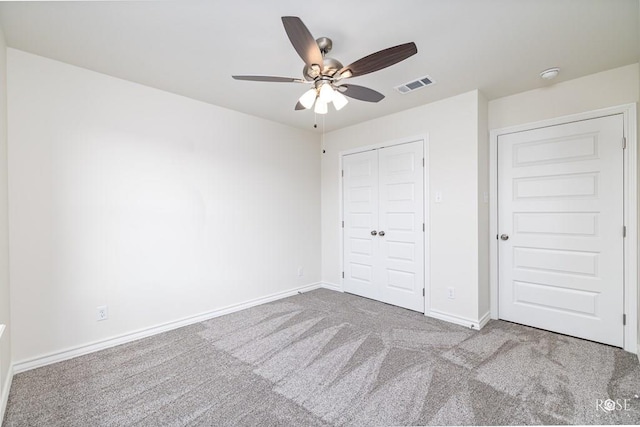 unfurnished bedroom featuring ceiling fan, carpet floors, visible vents, baseboards, and a closet