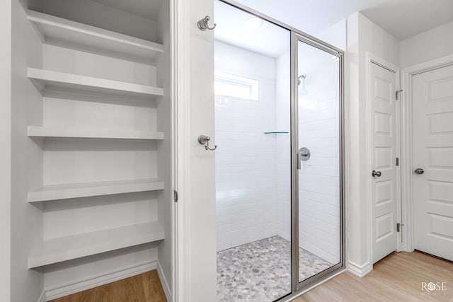 bathroom with hardwood / wood-style flooring and an enclosed shower