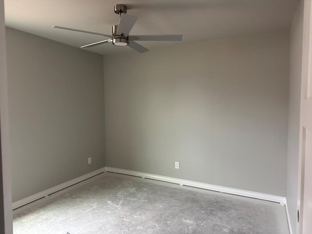 spare room with ceiling fan and concrete floors