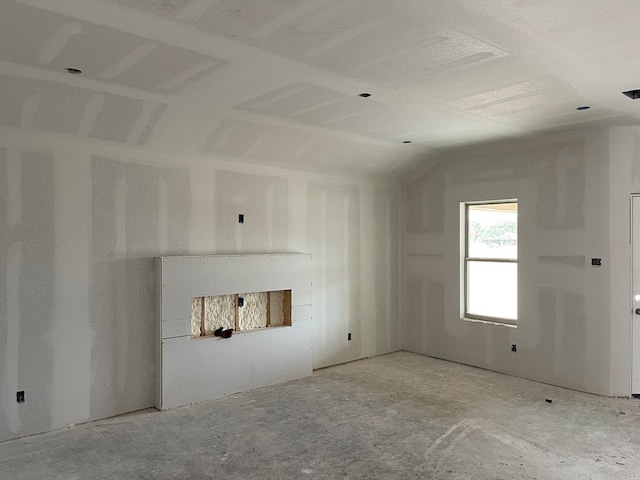 unfurnished living room featuring vaulted ceiling