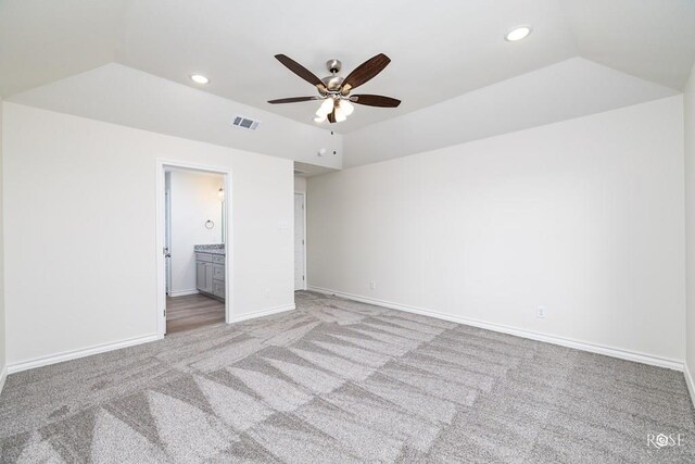 unfurnished bedroom featuring ceiling fan, lofted ceiling, light carpet, and ensuite bath