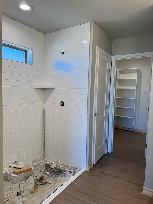 full bathroom featuring tiled shower and wood finished floors