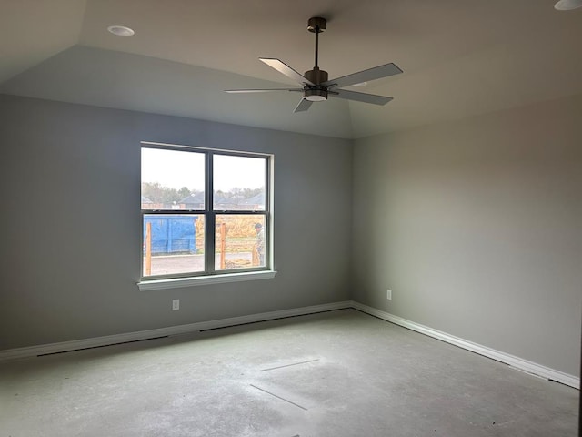 empty room featuring concrete flooring, vaulted ceiling, and ceiling fan