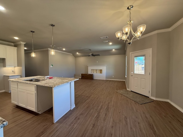 kitchen featuring ceiling fan, dark wood-type flooring, a fireplace, visible vents, and white cabinets