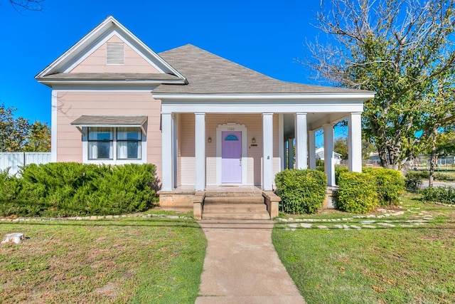 neoclassical home featuring a porch and a front lawn