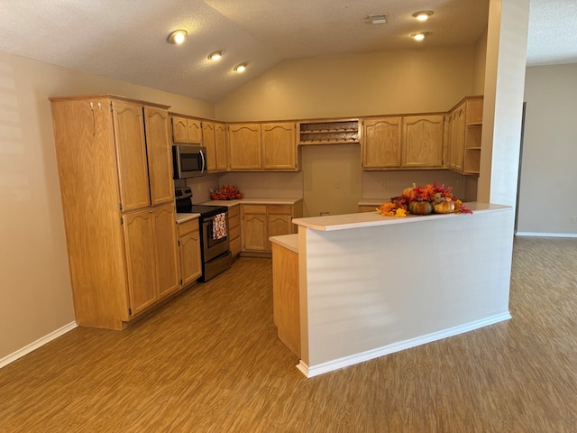 kitchen featuring vaulted ceiling, light brown cabinets, kitchen peninsula, stainless steel appliances, and light hardwood / wood-style floors