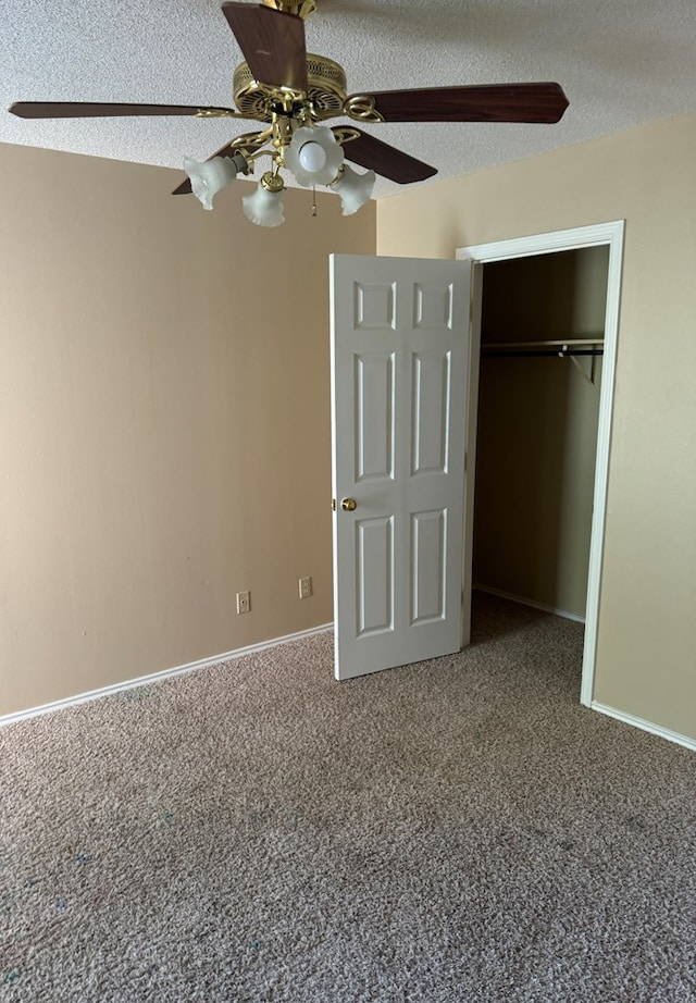 unfurnished bedroom featuring ceiling fan, carpet floors, a closet, and a textured ceiling