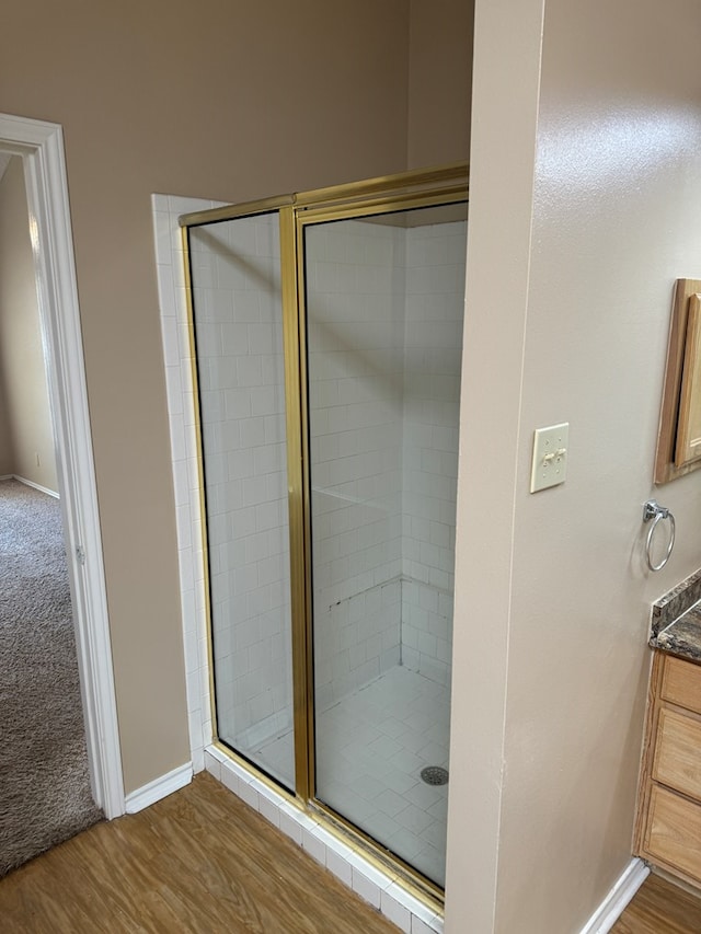 bathroom with vanity, a shower with door, and hardwood / wood-style floors