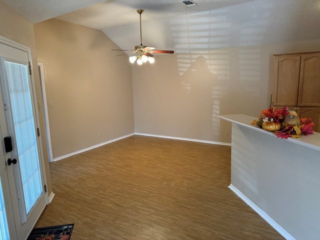 interior space with hardwood / wood-style flooring, vaulted ceiling, and a textured ceiling