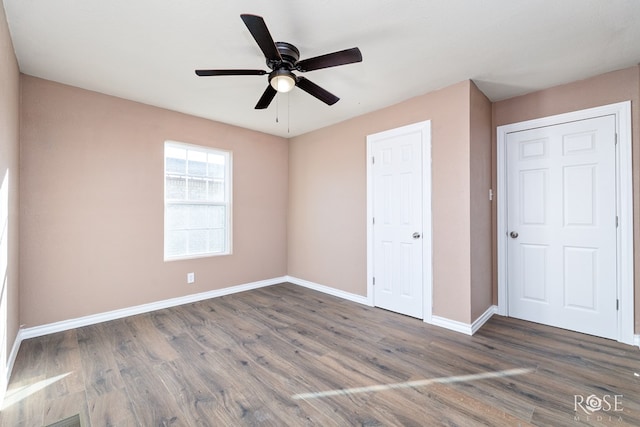 unfurnished bedroom featuring dark hardwood / wood-style floors and ceiling fan