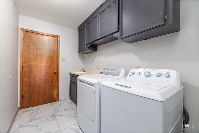 clothes washing area featuring separate washer and dryer, sink, and cabinets