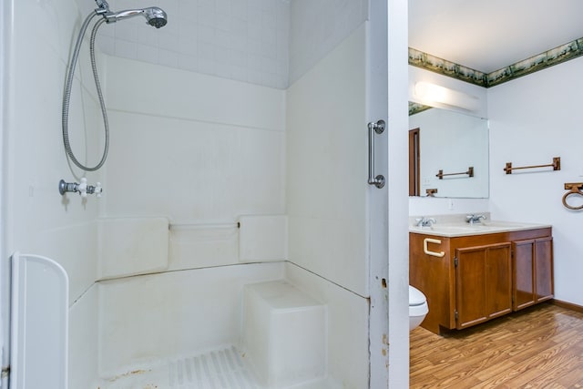 bathroom featuring walk in shower, vanity, toilet, and hardwood / wood-style floors