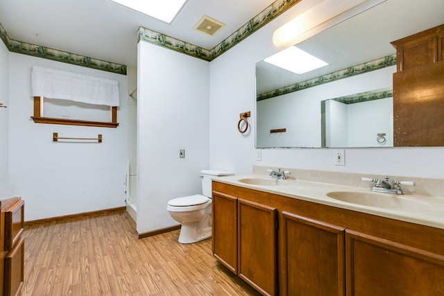 bathroom featuring vanity, hardwood / wood-style floors, and toilet