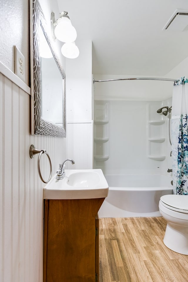 full bathroom with shower / tub combo, vanity, toilet, and hardwood / wood-style floors