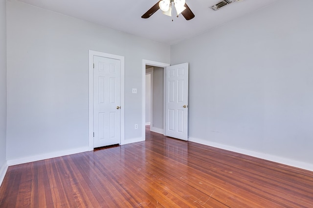 spare room featuring visible vents, wood-type flooring, baseboards, and ceiling fan