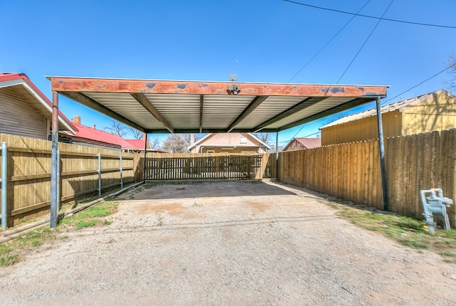 view of car parking with a carport, concrete driveway, and fence