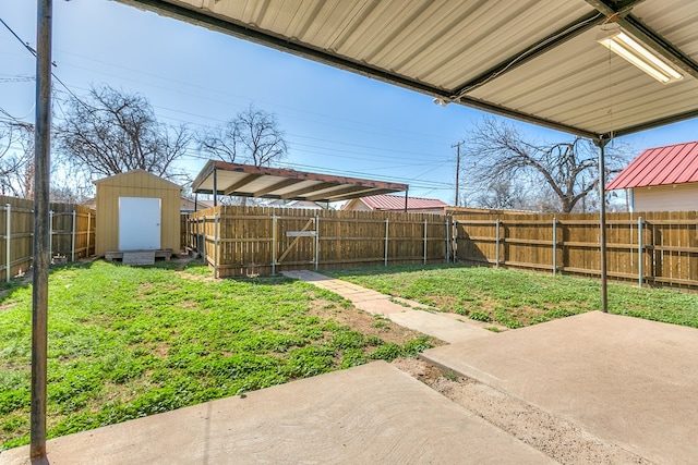 view of yard featuring an outbuilding, a storage unit, a patio area, and a fenced backyard