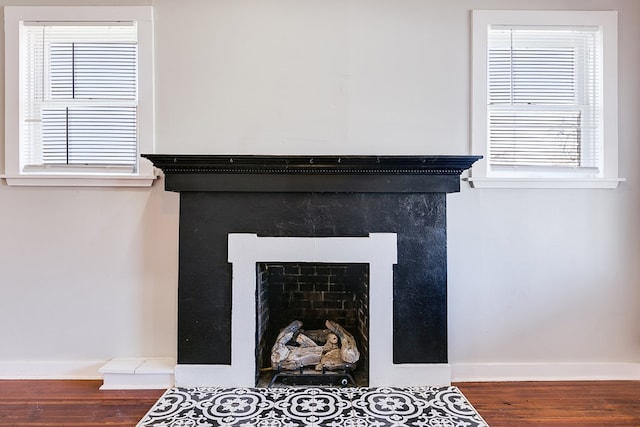 interior details with baseboards, wood finished floors, and a tile fireplace