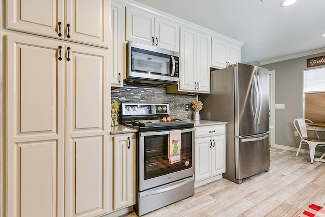 kitchen featuring tasteful backsplash, white cabinets, ornamental molding, stainless steel appliances, and light wood-type flooring