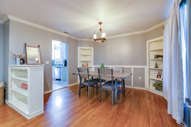 dining space with an inviting chandelier, wood-type flooring, crown molding, and built in features