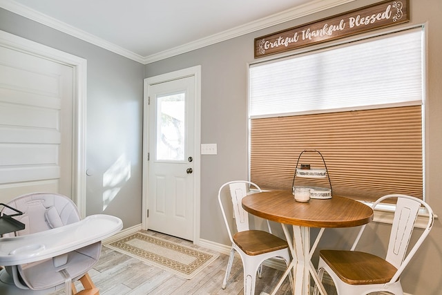 dining space with crown molding and light wood-type flooring