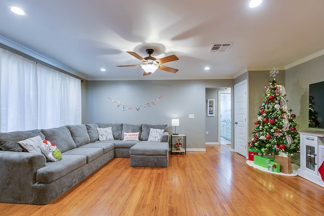 living room with light hardwood / wood-style flooring, ornamental molding, and ceiling fan