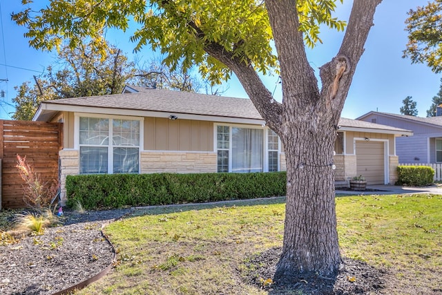 ranch-style home with a garage and a front lawn