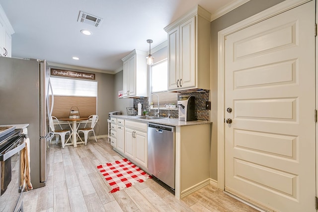 kitchen featuring pendant lighting, stainless steel appliances, crown molding, and white cabinets