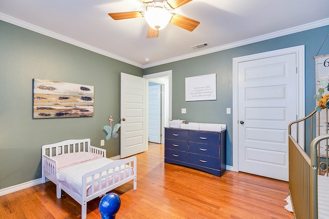 bedroom featuring ceiling fan, ornamental molding, and hardwood / wood-style floors