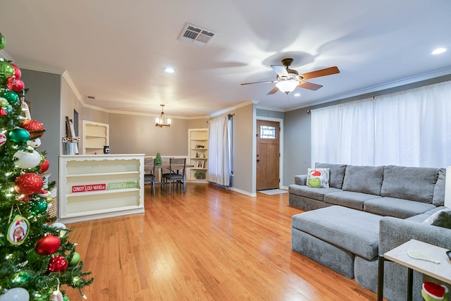 living room with hardwood / wood-style flooring, ceiling fan with notable chandelier, and ornamental molding