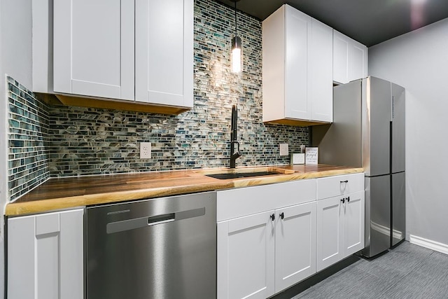 220-K W Twohig Ave, San Angelo, TX 76901 - kitchen with stainless steel appliances, wood counters, a sink, and tasteful backsplash