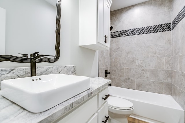 full bathroom with tiled shower / bath, vanity, and toilet