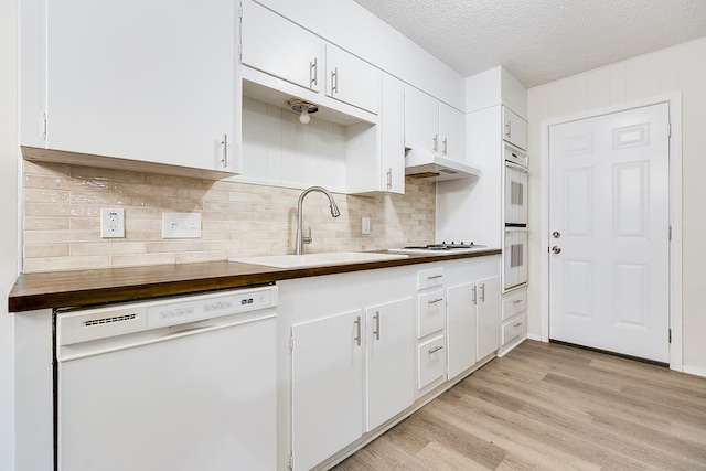 1809 N Harrison St, San Angelo, TX 76901 - kitchen featuring a sink, white appliances, light wood-type flooring, white cabinetry, and backsplash
