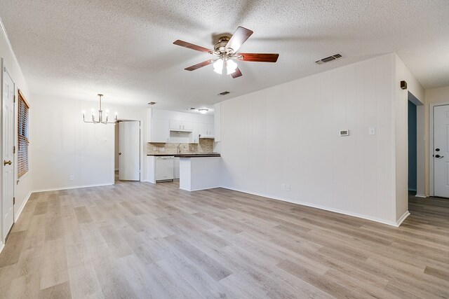 1809 N Harrison St, San Angelo, TX 76901 - unfurnished living room with a sink, ceiling fan with notable chandelier, a textured ceiling, light wood-type flooring, and visible vents