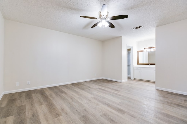 1809 N Harrison St, San Angelo, TX 76901 - empty room with visible vents, light wood-style flooring, ceiling fan, and a textured ceiling