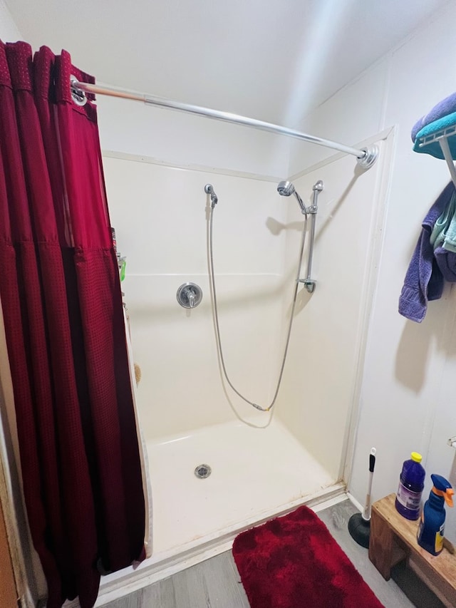 bathroom featuring hardwood / wood-style flooring and curtained shower