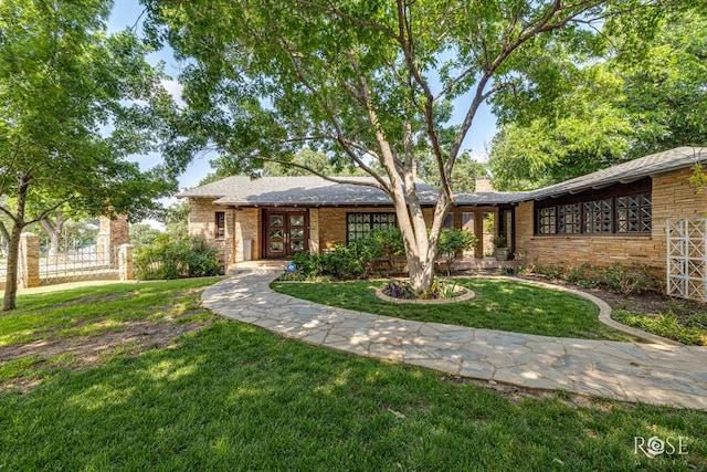 1703 Christoval Rd, San Angelo, TX 76903 - view of front facade with a front lawn, brick siding, and french doors