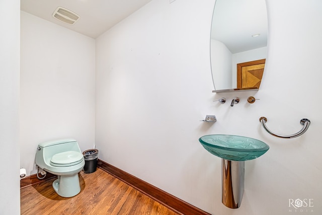 1703 Christoval Rd, San Angelo, TX 76903 - half bath featuring toilet, wood finished floors, and baseboards