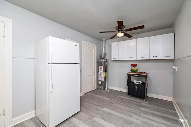 kitchen with freestanding refrigerator, white cabinets, ceiling fan, gas water heater, and light wood-type flooring