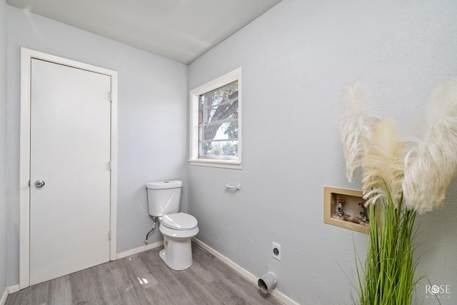 bathroom with toilet, wood finished floors, and baseboards