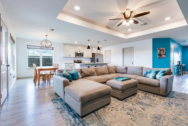 1501 Montague Ave, San Angelo, TX 76905 - living area featuring a tray ceiling, a chandelier, light wood finished floors, ceiling fan, and recessed lighting
