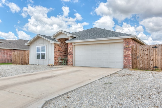 1501 Montague Ave, San Angelo, TX 76905 - ranch-style house with board and batten siding, driveway, an attached garage, brick siding, and a shingled roof