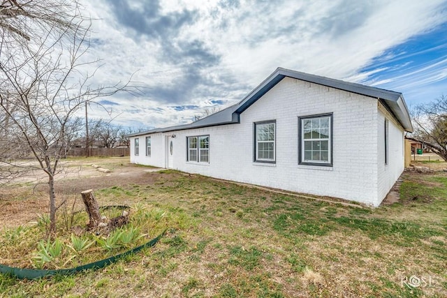 view of property exterior featuring a lawn and brick siding