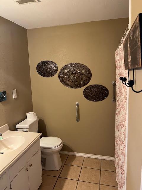 bathroom featuring tile patterned flooring, vanity, and toilet