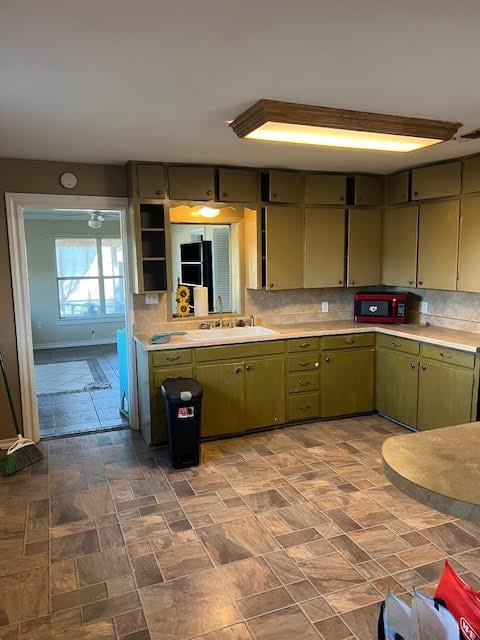 kitchen featuring tasteful backsplash, sink, and green cabinetry