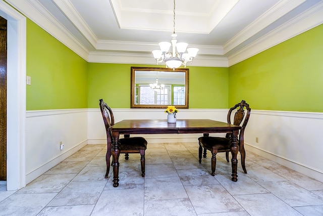 dining room featuring an inviting chandelier, crown molding, and a raised ceiling