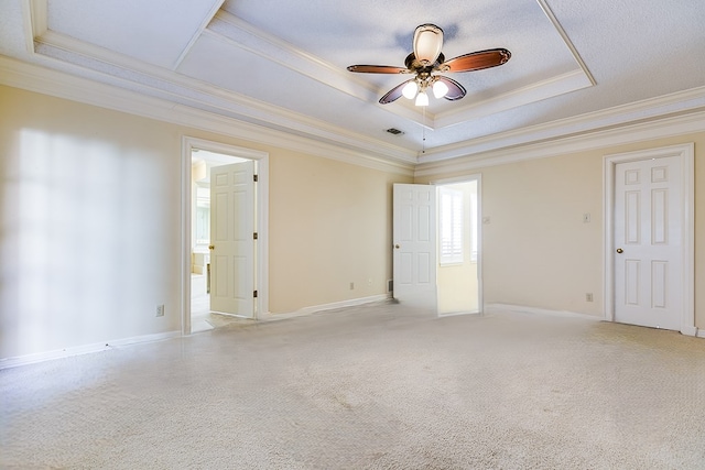 carpeted empty room featuring a raised ceiling, ornamental molding, and ceiling fan