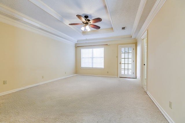 unfurnished room with crown molding, ceiling fan, a textured ceiling, light colored carpet, and a raised ceiling