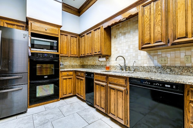 kitchen with sink, decorative backsplash, light stone counters, black appliances, and crown molding