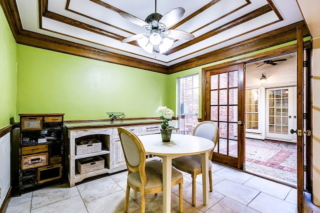 tiled dining area with ornamental molding, a tray ceiling, ceiling fan, and french doors